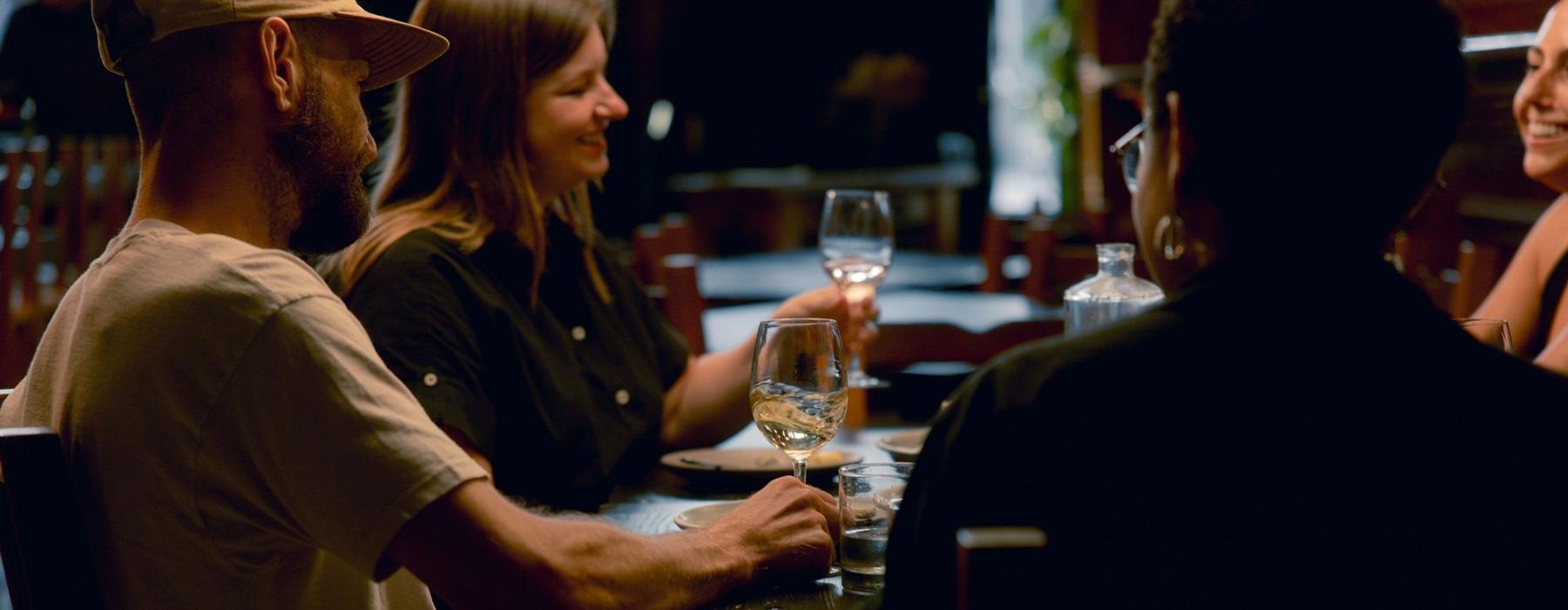 A group of people sitting at a table with wine glasses.